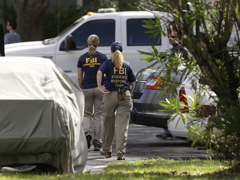 FBI investigators walk near the crime scene of an apartment where a man was shot by an FBI agent, Wednesday, May 22, 2013, in Orlando, Fla. The man who was shot and killed by the agent early this morning was friends with the Boston bombings suspects, according to a friend of the victim. (AP Photo/John Raoux)