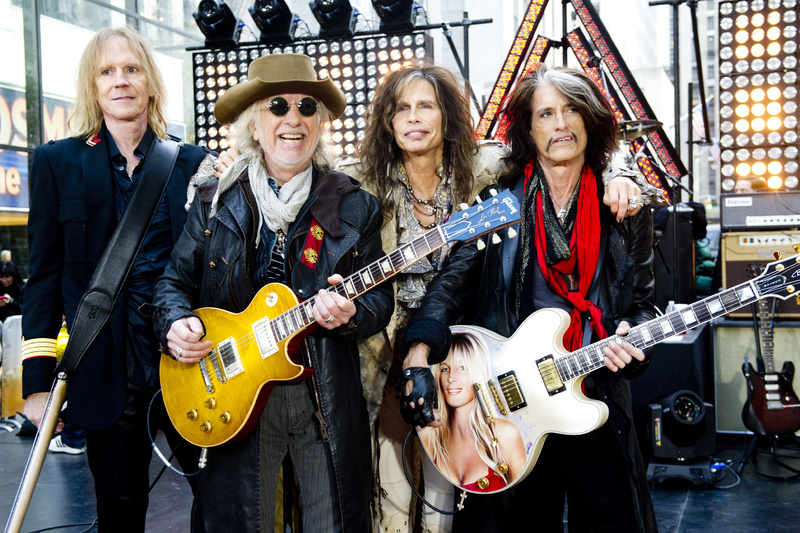 Aerosmith, from left, Tom Hamilton, Brad Whitford, Steven Tyler and Joe Perry, is among the scheduled performers for a Boston Marathon benefit concert May 30 at the TD Garden. Arm Around Shoulder,Concert,Gig,Guitar,Live Performance,On Stage,Small Group of People,Smiling