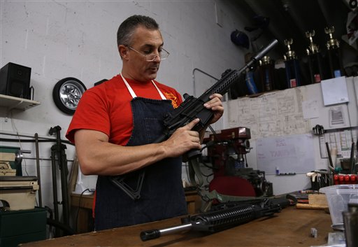 Jorge Corbato, 48, owner of Nebulous Ordnance, holds a M-16 rifle that he is servicing for a law enforcement official, Tuesday, April 9, 2013, in Miami. Corbato is a gun manufacturer who custom builds AR-15 rifles, services guns, and restores historic pieces for museums and collectors. Since the Sandy Hook school shootings in Newtown, Connecticut, Corbato says the supply for components needed to build the AR-15 has gone down, while prices have gone up. Lawmakers in Congress hope to gain a Senate floor vote on meaningful gun restrictions this week. (AP Photo/Lynne Sladky)