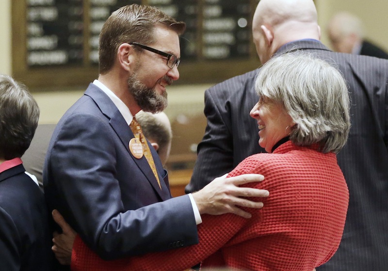 In this May 9, 2013 file photo, gay marriage sponsors Rep. Karen Clark, right, and Sen. Scott Dibble celebrate after the Minnesota House passed the gay marriage bill in St. Paul, Minn. The two openly gay Minnesota state lawmakers, who respectively sponsored the measure in the state House and Senate, prepared to watch Democratic Gov. Mark Dayton sign the bill in a ceremony Tuesday, May 14, 2013, on the front steps of Minnesota’s Capitol. (AP Photo/Jim Mone, File)