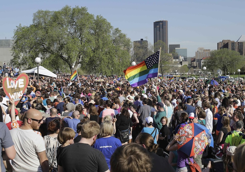 An estimated 6,000 people gathered at the State Capitol where Minnesota Gov. Mark Dayton signed the gay marriage bill, Tuesday, May 14, 2013, in St. Paul, Minn. Minnesota becomes the 12th state to legalize gay marriage. (AP Photo/Jim Mone)