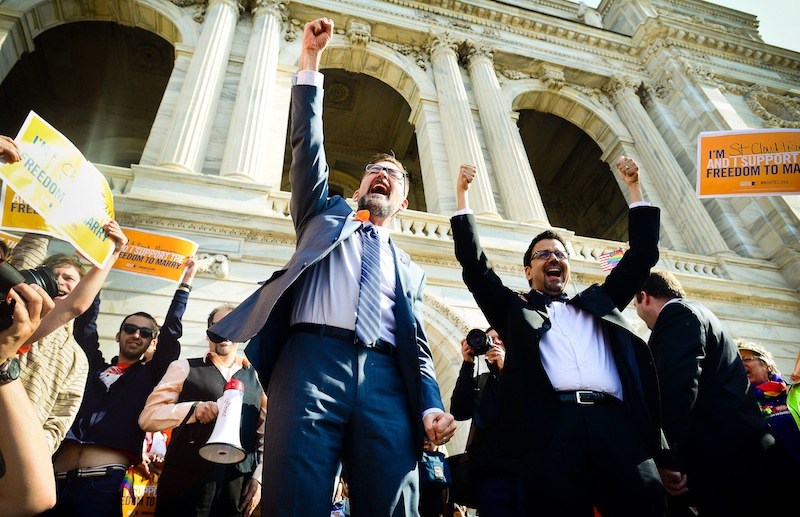 Sen. Scott Dibble, DFL-Minneapolis, left, sponsor of the gay marriage bill in the Minnesota Senate, and his partner Richard Leyva greet a large, joyous crowd as the arrive at the Minnesota State Capitol in St. Paul, Minn. on Monday, May 13, 2013. The Minnesota Senate is scheduled open debate at noon on a bill that would make Minnesota the 12th state to legalize gay marriage and the first to pass such a measure out of its Legislature. The chamber's majority Democratic leaders have said they expect it to pass and Democratic Gov. Mark Dayton has promised to sign it. (AP Photo/The St. Paul Pioneer Press, Ben Garvin) MINNEAPOLIS STAR TRIBUNE OUT