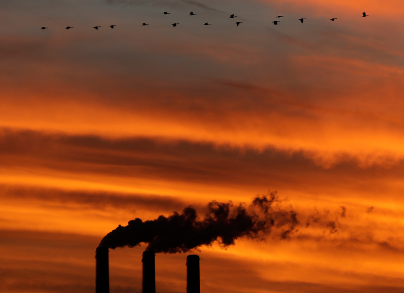 Geese fly past the smokestacks at the Jeffrey Energy Center coal power plant as the suns sets near Emmett, Kan. Worldwide levels of the chief greenhouse gas that causes global warming have hit a milestone, federal scientists said Friday.