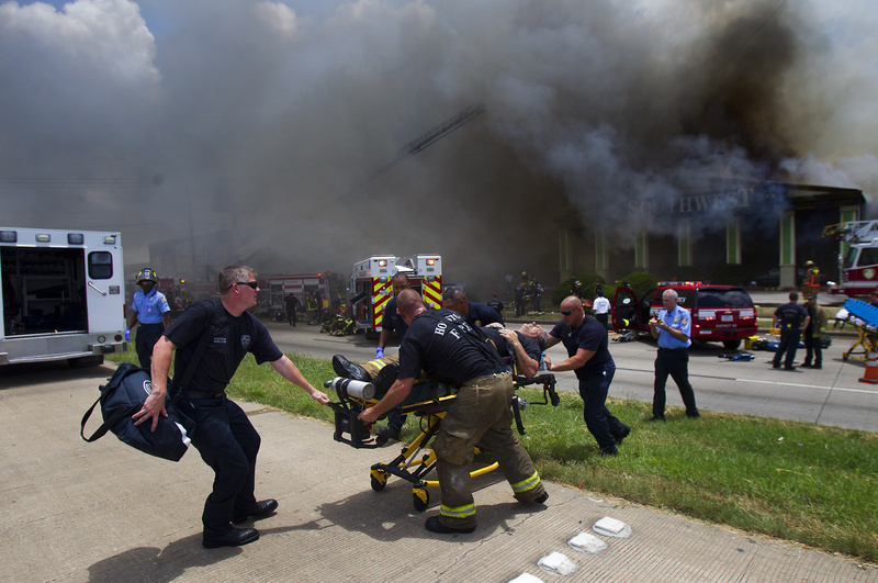 A firefighter is wheeled to an ambulance after fighting a fire at the Southwest Inn on Friday in Houston.