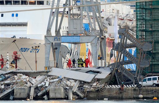 Rescue personnel stand on rubble next to a tilted staircase, part of a control tower that collapsed after a cargo ship slammed into it Tuesday night in the port of Genoa, northern Italy.