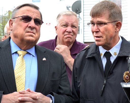 Gov. Paul LePage, left, and Lewiston Mayor Robert Macdonald, center, look up at two burned-out apartment buildings on Bartlett Street in Lewiston on Tuesday.