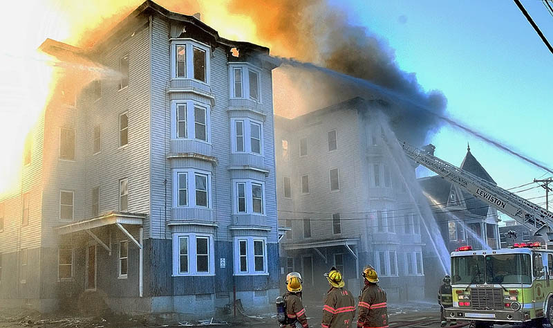In this May 6 photo, firefighters battle the third major Lewiston fire in in a week, this one at 114-118 Bartlett Street. The four people accused of setting the three fires, which displaced about 200 residents, are due in Lewiston District Court today.