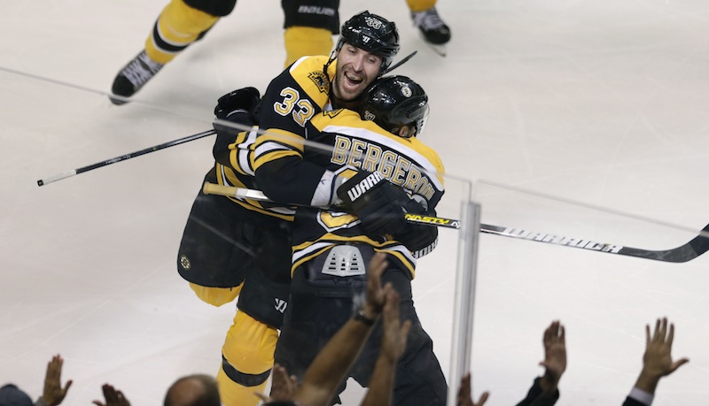 Boston Bruins center Patrice Bergeron (37) is embraced by teammate Zdeno Chara (33) after scoring the game winning goal off Toronto Maple Leafs goalie James Reimer during overtime in Game 7 of their NHL hockey Stanley Cup playoff series in Boston, Monday, May 13, 2013. The Bruins won 5-4. (AP Photo/Charles Krupa)