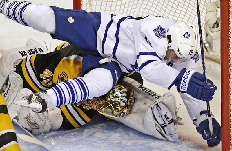 Toronto Maple Leafs right wing Joffrey Lupul, top, bends Boston Bruins goalie Tuukka Rask's head to his leg as he crashes into him while chasing the puck during the second period in Game 7 of their NHL hockey Stanley Cup playoff series in Boston, Monday, May 13, 2013. (AP Photo/Charles Krupa)