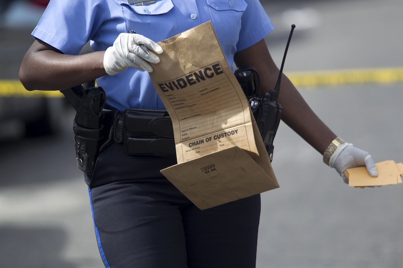 New Orleans police officer collects evidence at the scene of a shooting at the intersection Frenchman Street at N. Villere on Mother's Day in New Orleans, Sunday May 12, 2013. Gunmen opened fire on dozens of people marching in a Mother's Day neighborhood parade in New Orleans on Sunday, wounding at least 17, police said. (AP Photo/Doug Parker) New Orleans Police;Shooting