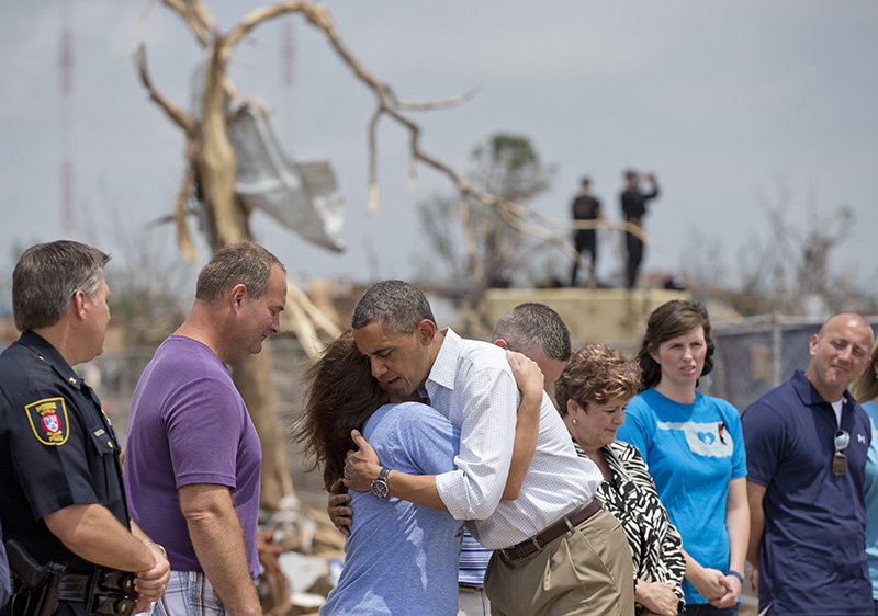 President Barack Obama embraces a school official as he views the devastation of the Plaza Towers Elementary School, Sunday, May 26, 2013, in Moore, Okla., caused by tornado and severe weather last week.