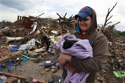 Austin Brock holds cat Tutti, shortly after the animal was retrieved from the rubble of Brock's home, which was demolished by Monday's tornado.