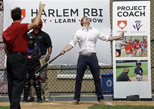 Prince Harry reacts after hitting a baseball pitched to him by New York Yankees' Mark Teixeira, left, during a visit to the Harlem RBI youth sports and school program in New York on Tuesday.