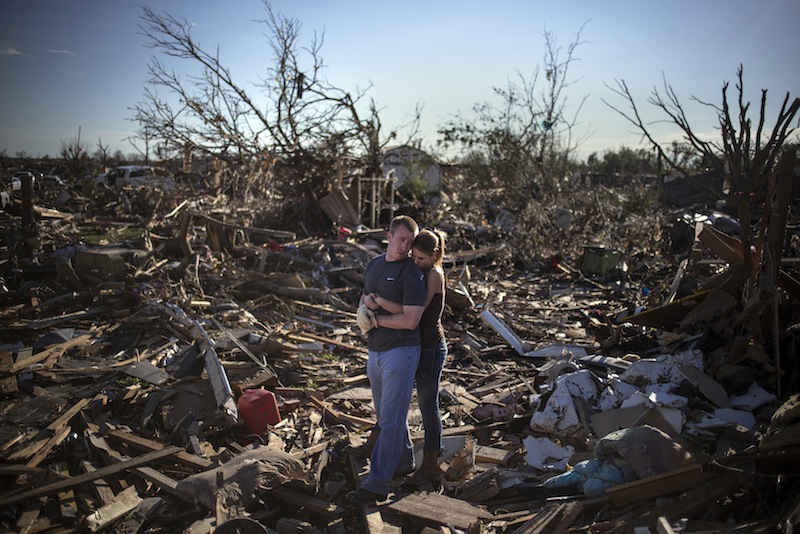 Danielle Stephan holds boyfriend Thomas Layton as they pause between salvaging through the remains of a family member's home one day after a tornado devastated the town Moore, Oklahoma, in the outskirts of Oklahoma City May 21, 2013. Rescuers went building to building in search of victims and thousands of survivors were homeless on Tuesday after a massive tornado tore through the Oklahoma City suburb of Moore, wiping out whole blocks of homes and killing at least 24 people. (REUTERS/Adrees Latif) :rel:d:bm:GF2E95M00JG01