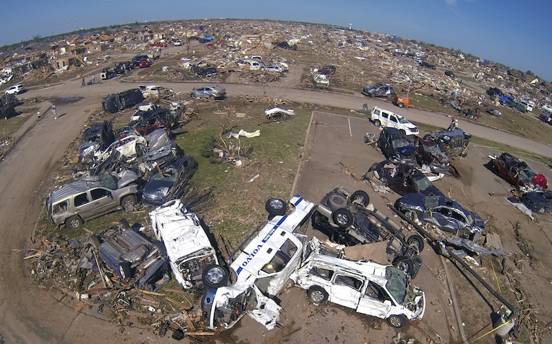 A pile of destroyed cars of teachers sits outside Briarwood elementary school in Oklahoma City, Oklahoma May 22, 2013. Rescue workers with sniffer dogs picked through the ruins on Wednesday to ensure no survivors remained buried after a deadly tornado left thousands homeless and trying to salvage what was left of their belongings. Curvature of horizon in the photo is due to an ultra-wide angle lens. (REUTERS/Rick Wilking) :rel:d:bm:GF2E95M1QVR01