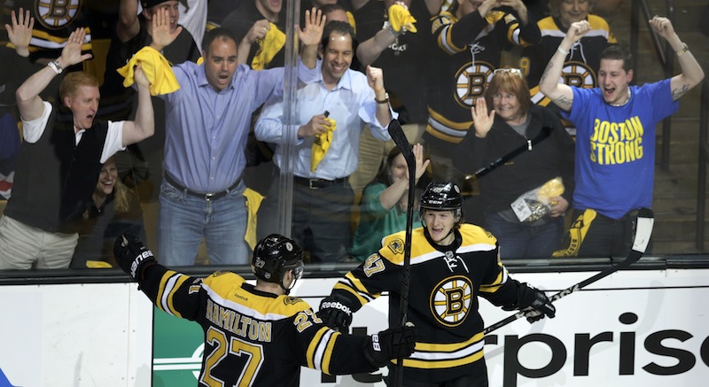 Fans celebrate as Boston Bruins defenseman Torey Krug, front right, is congratulated by teammate Dougie Hamilton after his goal against the New York Rangers during the third period in Game 1 of an NHL playoff series Thursday in Boston.