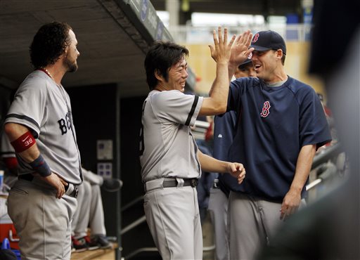 Boston Red Sox relief pitcher Koji Uehara, center, is congratulated by starting pitcher John Lackey, right, as catcher Jarrod Saltalamacchia, left, looks on Sunday in Minneapolis.