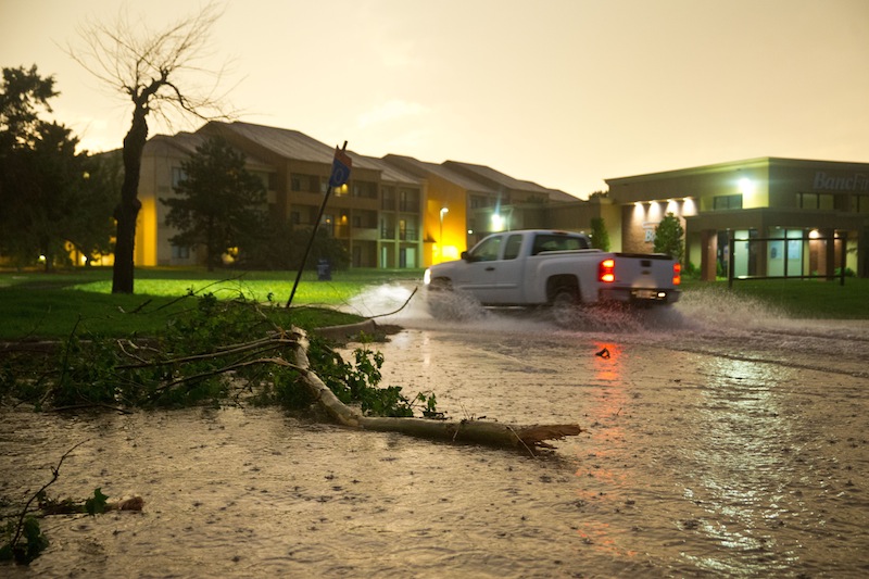 A pickup truck drives through a flooded Highline Blvd just east of South Meridian Ave where several trees were also down after a tornado on the ground near El Reno Okla. just south of Interstate 40 on Friday May 31, 2013. (AP Photo/The World-Herald, Chris Machian)