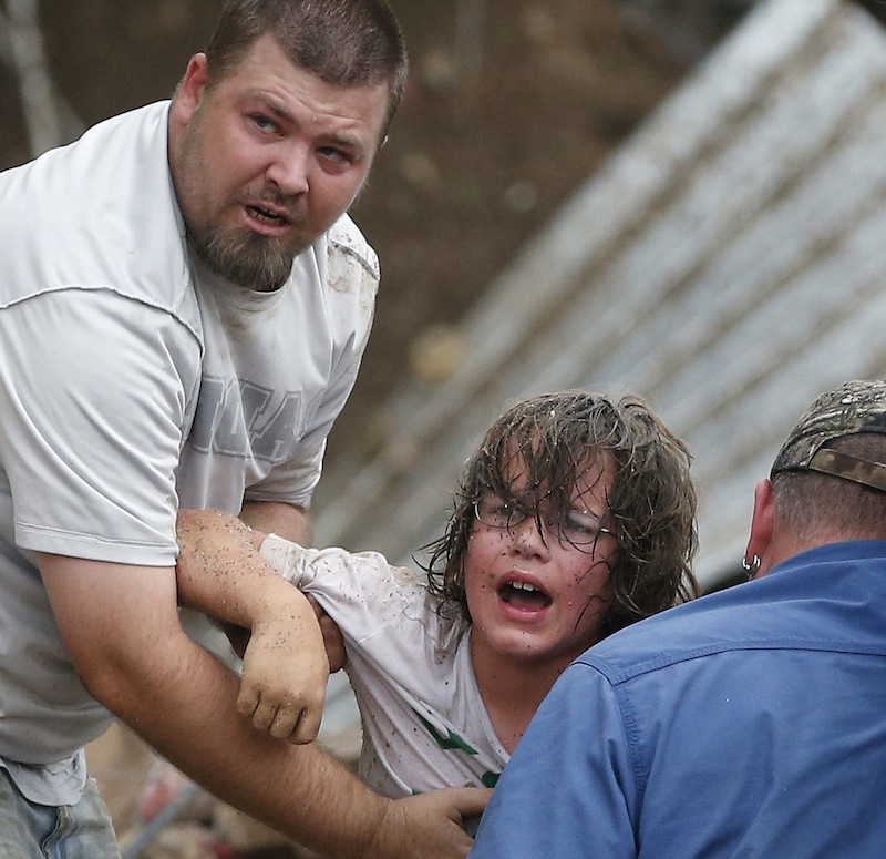 A child calls to his father after being pulled from the rubble of the Tower Plaza Elementary School following a tornado in Moore, Okla., Monday, May 20, 2013. A tornado as much as a mile (1.6 kilometers) wide with winds up to 200 mph (320 kph) roared through the Oklahoma City suburbs Monday, flattening entire neighborhoods, setting buildings on fire and landing a direct blow on an elementary school. (AP Photo Sue Ogrocki)