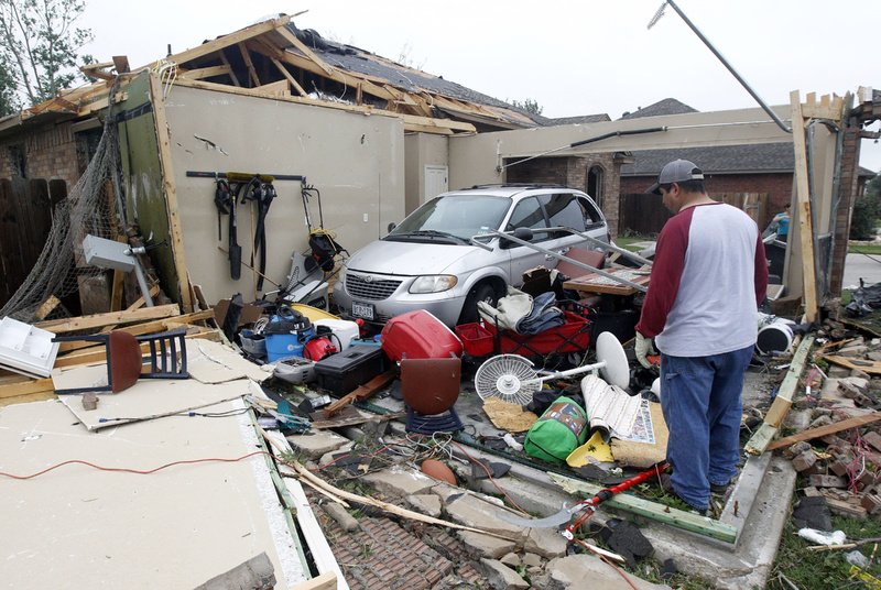 Pete Alaniz looks for items to salvage Thursday after a tornado hit his home in Cleburne, Texas. His family of four and three dogs hid in a closet while the tornado destroyed his home. A rash of tornadoes slammed into several small communities in North Texas overnight, leaving at least six people dead, dozens more injured and hundreds homeless.