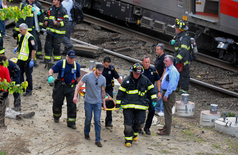 Injured passengers are transported from the scene where two Metro North commuter trains collided on Friday near Fairfield, Conn.