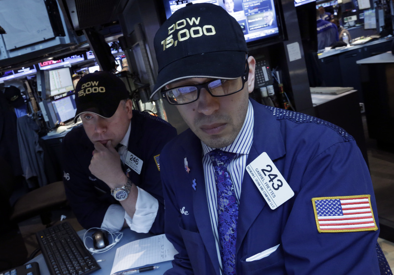 Specialists Devin Cryan, left, and Gabriel Freytes wear "Dow 15,000" hats as they work on the floor of the New York Stock Exchange on Friday. The Dow Jones industrial average crossed 15,000 for the first time, and the Standard and Poor's 500 index, a broader market measure, rose above 1,600.