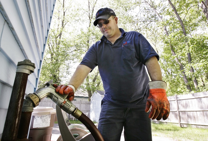 In this May 2008 file photo, Tim Weeks makes a home heating oil delivery in Portland, Maine. A legislative panel voted 12-1 Friday, May 24, 2013 to endorse an ambitious package of proposals aimed at lowering Maine's high electricity and heating costs. (AP Photo/Joel Page)