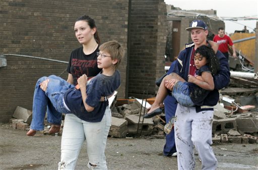 Teachers carry children away from Briarwood Elementary school after a tornado destroyed the school in south Oklahoma City, Okla, Monday, May 20, 2013.