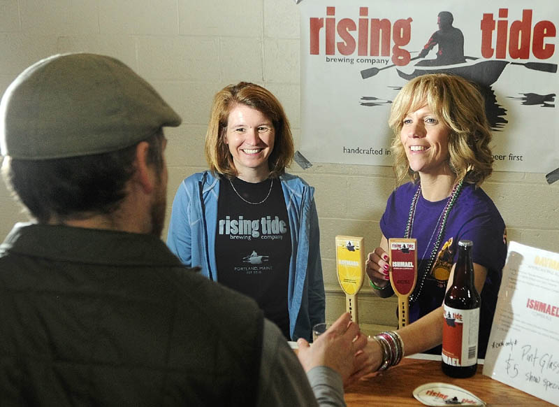 Brewery owner Heather Sanborn, left, and volunteer pourer Penny Vaillancourt talk to a customer at the Rising Tide booth at the Central Maine Brew Fest on April 13 in the Augusta Armory.