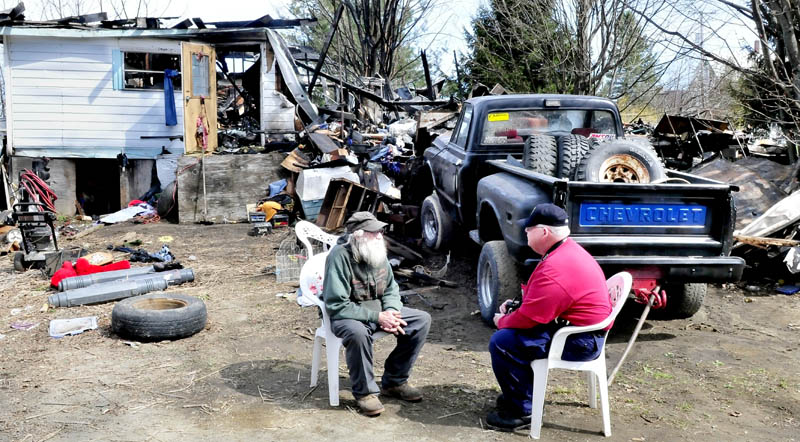Home owner Clyde Berry, left, speaks with state Fire Marshall's Office investigator Ken MacMaster outside the ruins of his home in Benton that was destroyed by fire early Monday, April 29, 2013.