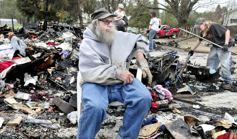 Clyde Berry on Thursday, May 2, 2013, speaks about the offers of help he has received amid the rubble of his home in Benton that was destroyed by fire last Monday. Looking for salvageable items in background are Barbara Berry, left, Jayme Sabins and Derrick Berry.