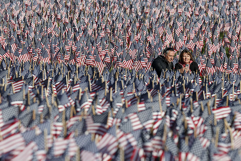 A couple photograph themselves amongst a sea of flags on Boston Common in Boston, Sunday, May 26, 2013. The flags were placed by the Massachusetts Military Heroes Fund in memory of every fallen Massachusetts service member from the Civil War to the present. (AP Photo/Michael Dwyer)
