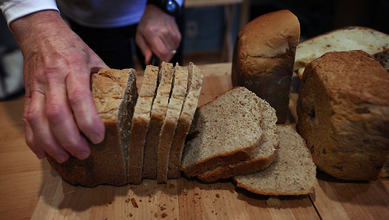 Dan Cole cuts bread into slices in preparation for serving.