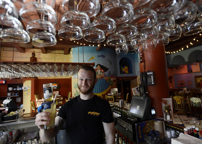 Jeff DiGiovanni, a bartender at Margaritas on Brown Street in Portland, presents a Coronarita, one of the more than a dozen types of margaritas the restaurant serves. Its happy hour specials include $1 baby chimis and $3 nachos.
