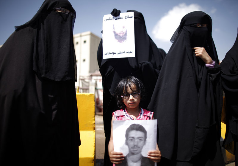 Faris al-Raimi, 5, holds a poster of his uncle during a protest to demand the release of Yemenis at Guantanamo Bay, Cuba, which holds 166 men captured in counterterrorism operations. Nearly all of them have been held for 11 years without charge.