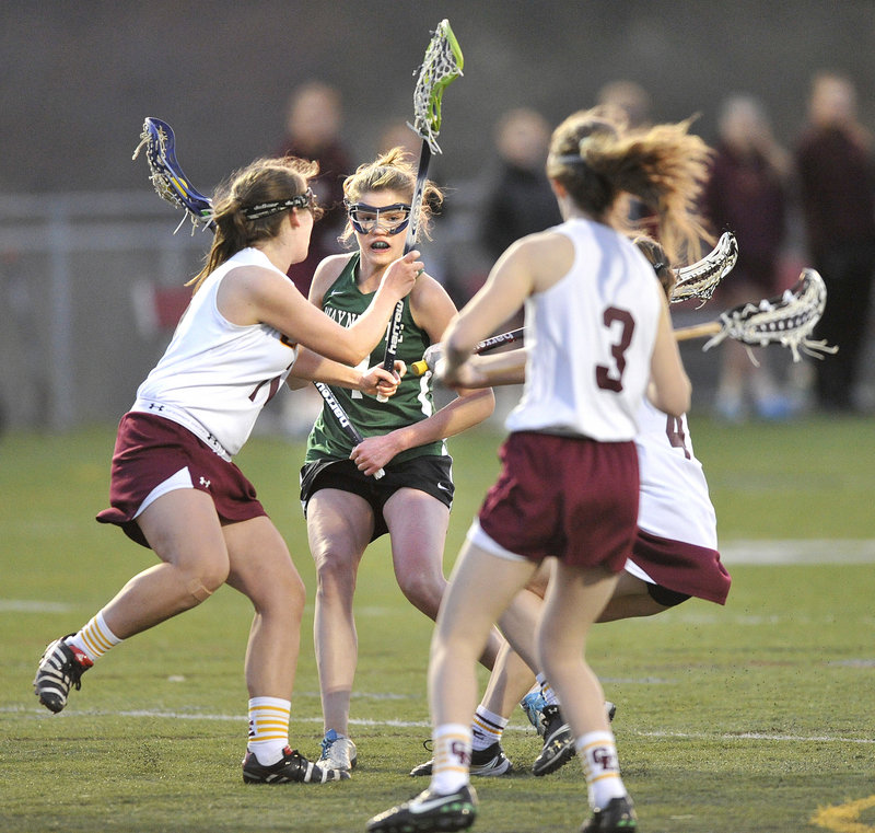 Walker Foehl of Waynflete finds herself surrounded by Cape Elizabeth defenders while trying to head to goal Wednesday night. Waynflete won in girls’ lacrosse, 10-8.