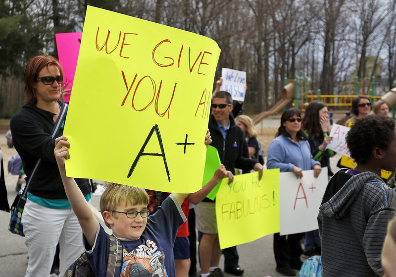 Harrison Greene, a student at the Fred P. Hall Elementary School, holds a sign in support of teachers at the school during a rally Thursday, May 2, 2013, to protest the grade of F given the school by the LePage administration.