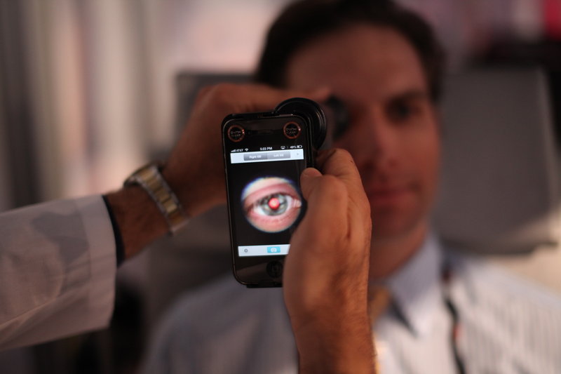 A medical student prepares to photograph the inside of an eye using a special tool that uses a smartphone camera during a recent TEDMED conference in Washington.