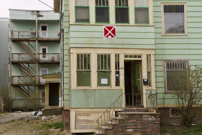 The building at 139 Bartlett St. wears the signature red square with a white “X,” designating it as a condemned property.