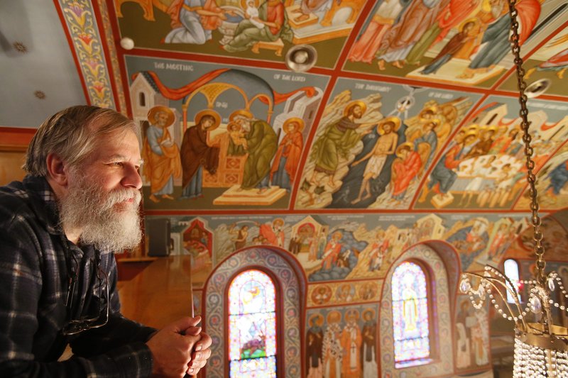The Rev. Theodore Jurewicz looks over the icons he painted over the last six years.