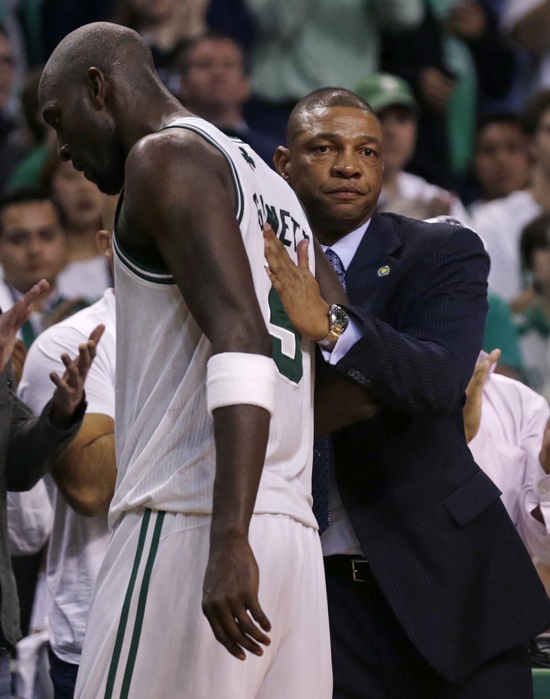 Coach Doc Rivers consoles a dejected Kevin Garnett late in Friday’s series-ending loss to the New York Knicks in Boston. Whether the veteran forward is back next fall remains to be seen.