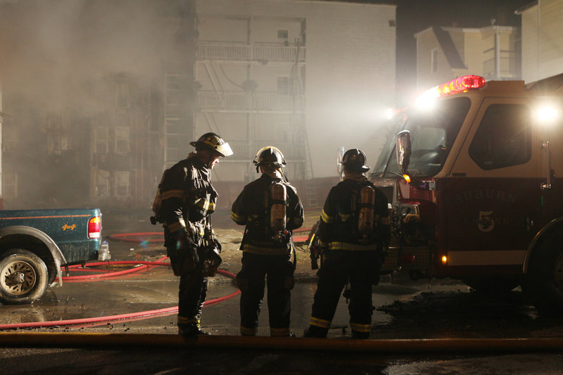 Firefighters confer at the scene of a Lewiston fire that destroyed 29 aparments early Saturday.