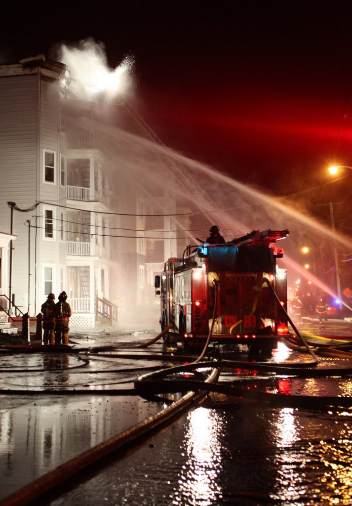 Early Saturday, firefighters train water toward the blazes that broke out in four buildings on Pierce and Bartlett streets in Lewiston. Fire investigators confirmed the fires started in a garage of a condemned property at 116 Pierce St.