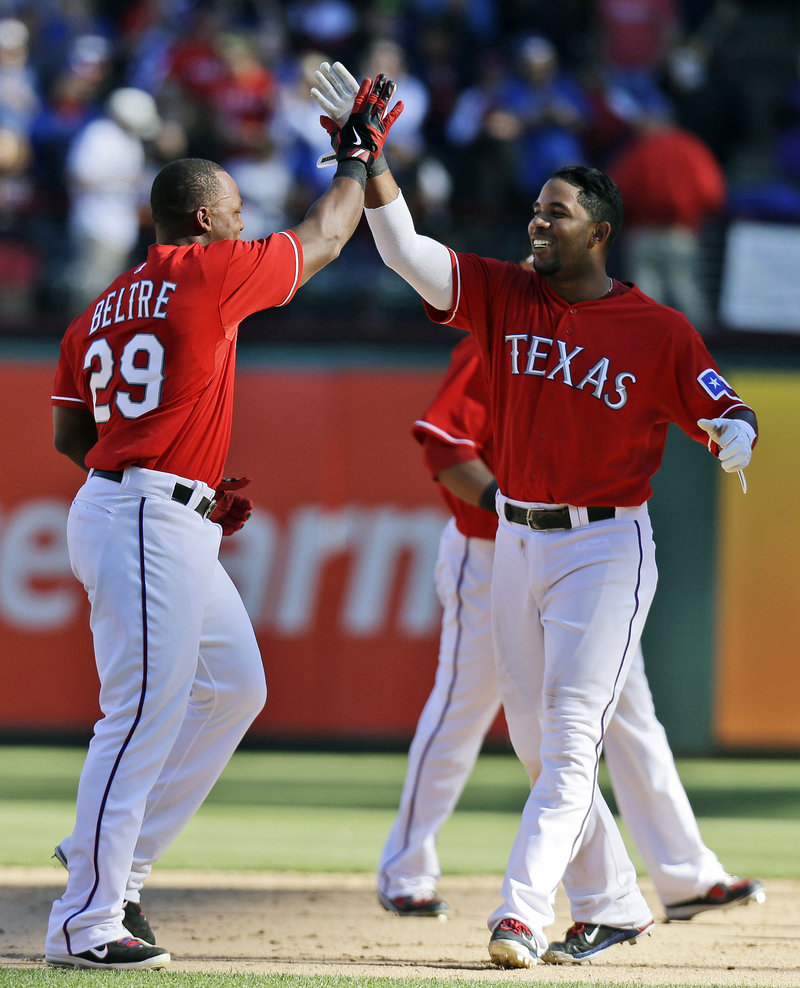 The Rangers’ Adrian Beltre, left, celebrates with Elvis Andrus after Beltre delivered a winning RBI single in the bottom of the ninth inning in a 4-3 win against the Red Sox at Arlington, Texas on Sunday.