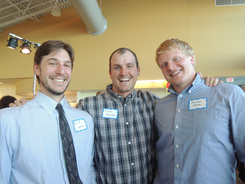 Auction volunteers Erik Lema, Tyler Gaudet and Phillip Szela, all of Portland, man the For Him tables at the fundraiser.