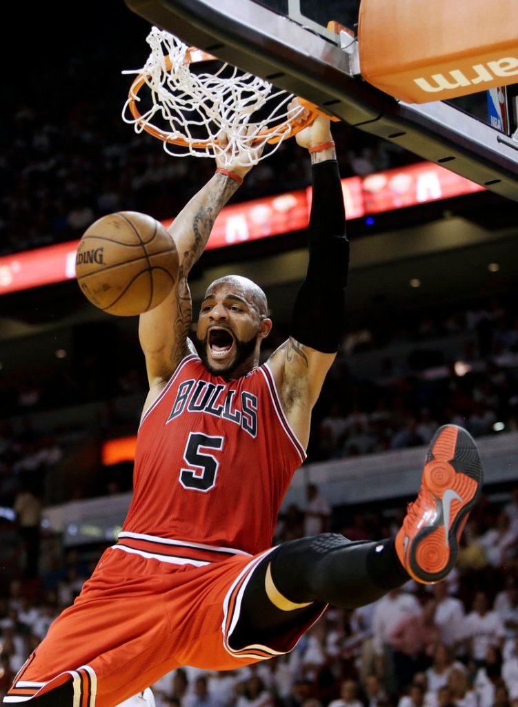 Bulls forward Carlos Boozer throws down an emphatic dunk during Chicago’s 93-86 upset win over the Heat in their playoff opener at Miami on Monday.