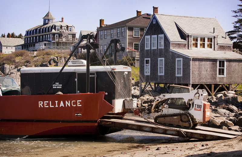 Contractors and equipment arrive on Monhegan, via landing vehicle, to take part in an Island Institute program to make Maine island homes more energy efficient. The workers eliminated air leaks in island homes by caulking cracks, installing weatherstripping and applying spray insulation.