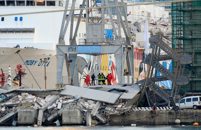 Rescue personnel stand in the wreckage of the control tower in the port of Genoa, Italy. At least seven were killed when the 40-ton ship slammed into the tower and dock.