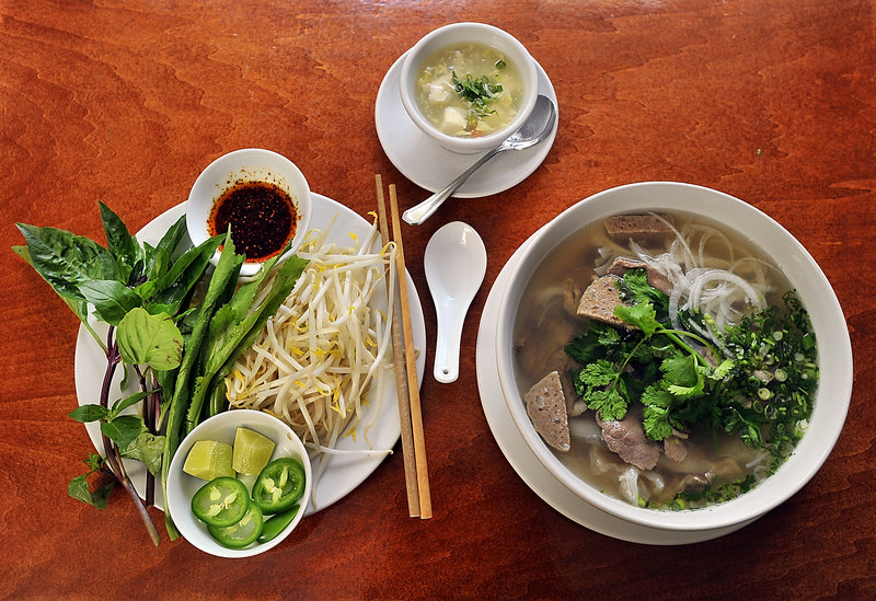 Saigon serves its beef pho with a plate of fresh basil, bean sprouts, lime and jalapeno pepper slices, and hot oil. It comes with a small bowl of tofu soup, top, as a starter. In the pho pictured are beef broth, noodles, onion, Asian cilantro and four kinds of meat.