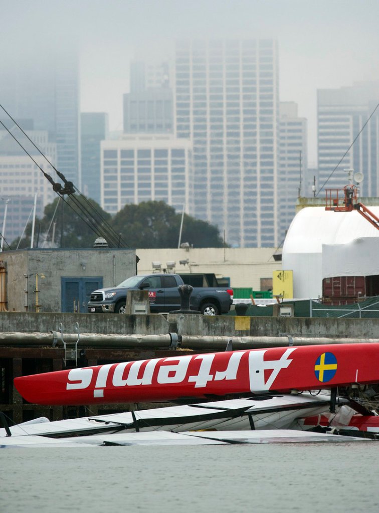 The Artemis catamaran floats upside down Friday in San Francisco, a day after sailor Andrew “Bart” Simpson died in the capsize.